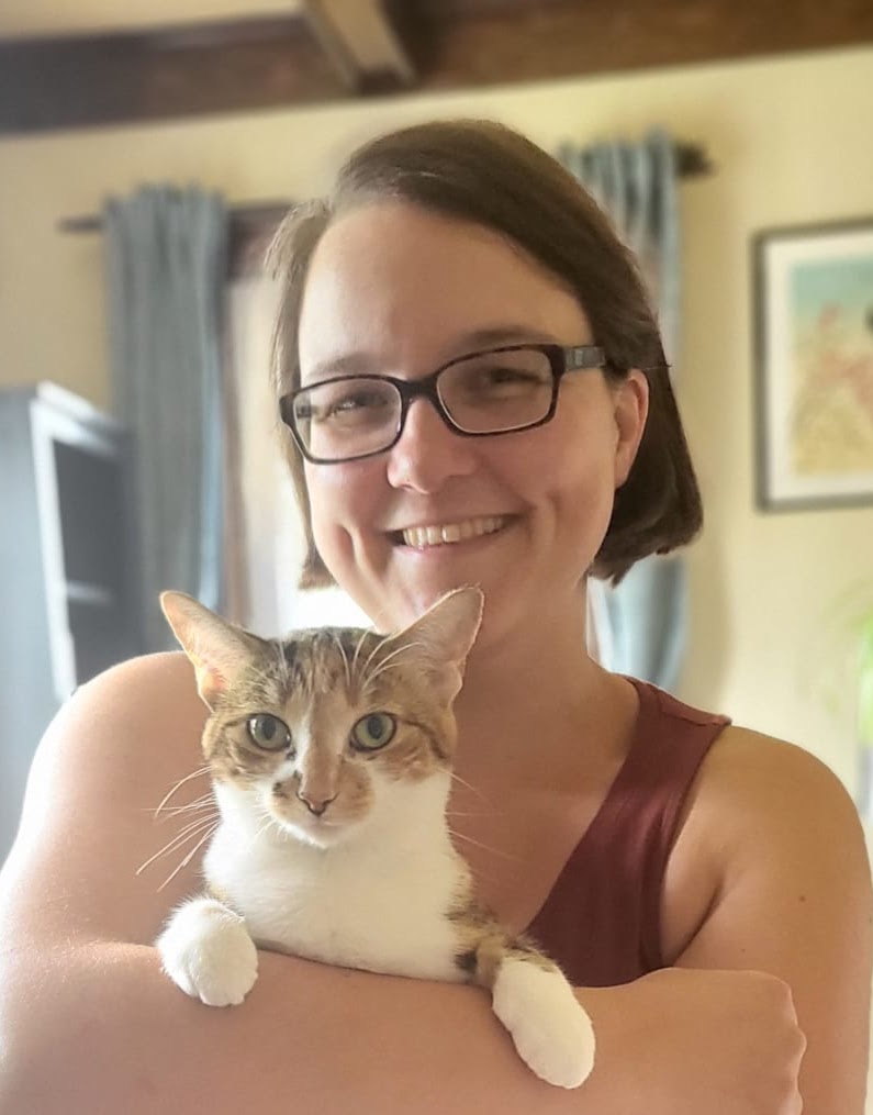 Steffi smiling and holding a cat in her arms